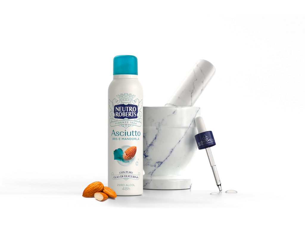 Deodorante Neutro Roberts Iris e Mandorla accanto a mortaio di marmo con mandorle.